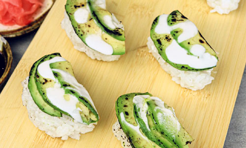 Avocado Nigiri sushi pieces on a tray